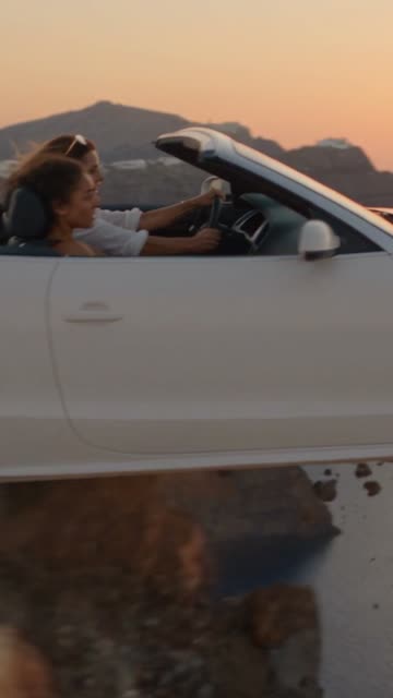 Minute 58: a convertible on a clifftop road at sunset